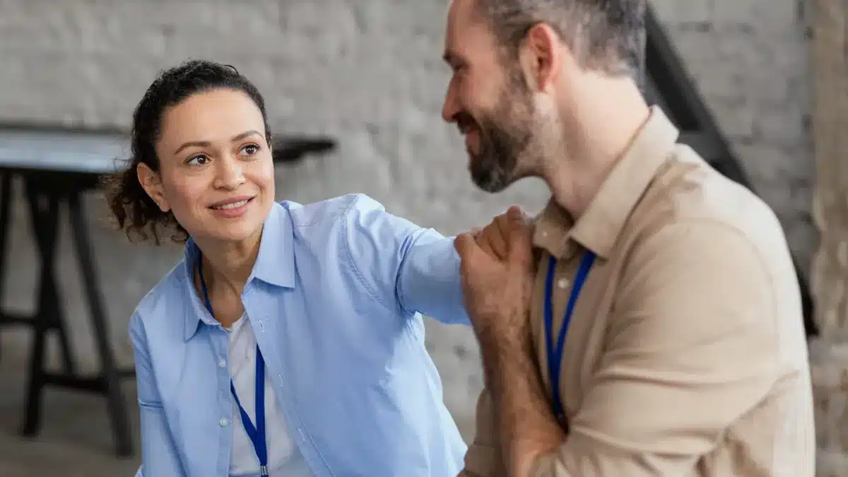 a importância da empatia ao lidar com colegas inseguros mulher sorri com empatia enquanto conforta colega de trabalho