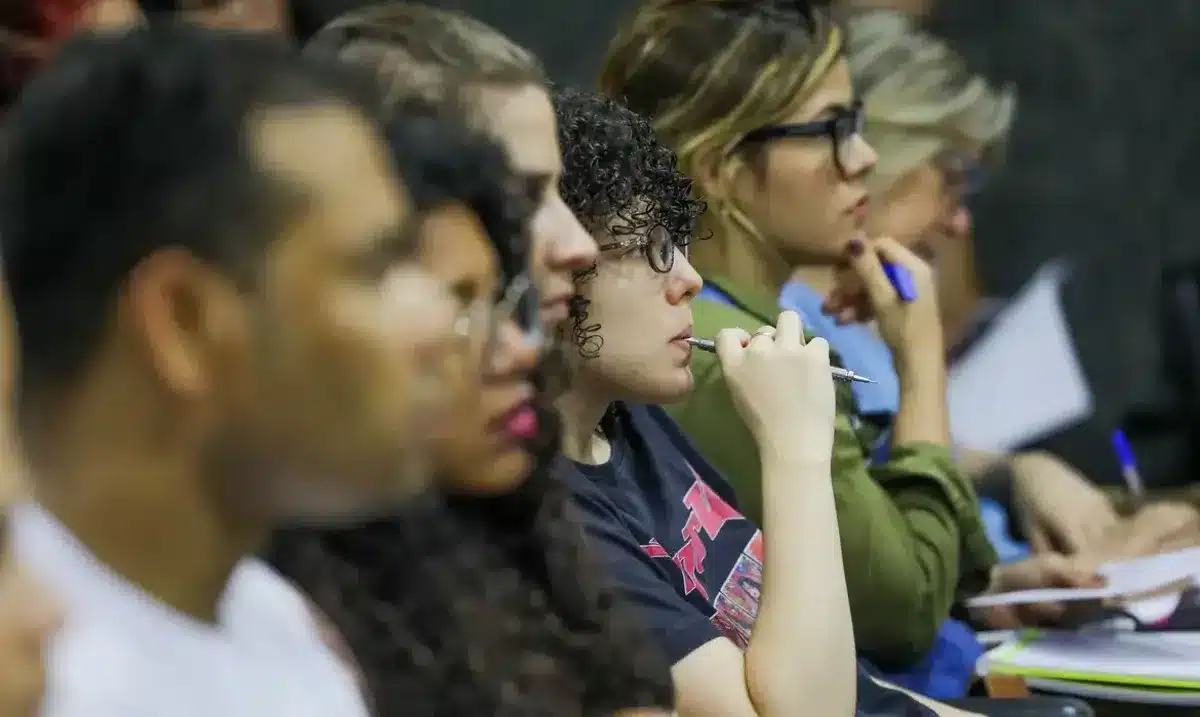 Concurso Câmera Municipal Grupo de pessoas assistindo atentamente em um evento ou palestra.