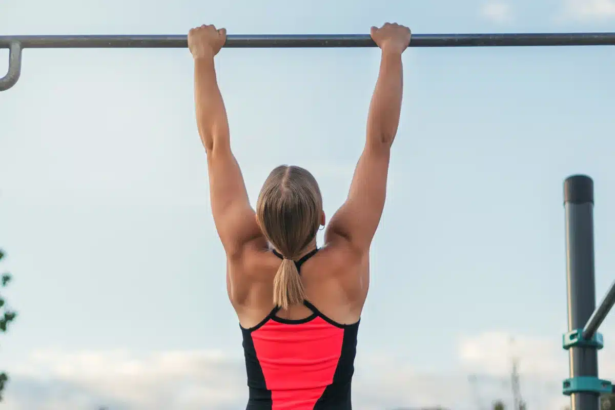 Avaliação da capacidade física Mulher realizando exercício de barra fixa como parte da avaliação física.