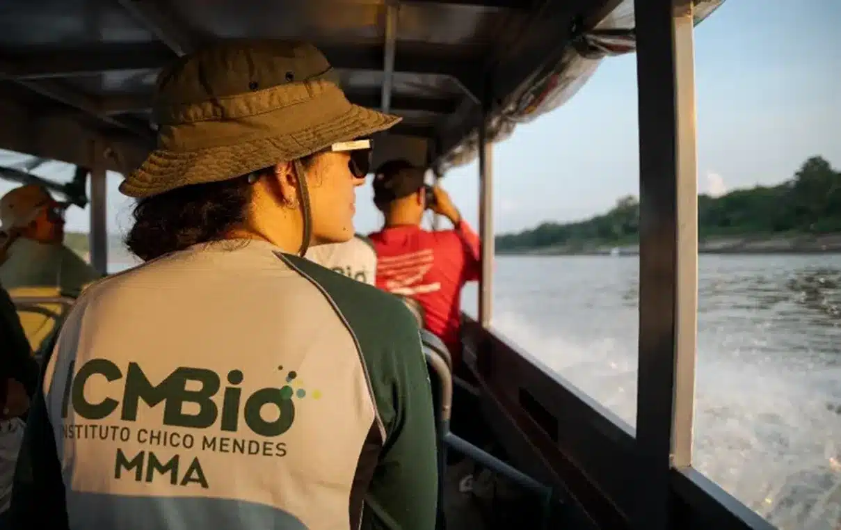 Profissional do ICMBio em ação, durante monitoramento em Unidade de Conservação, com vista para o rio.