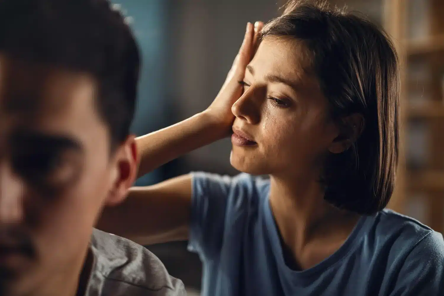 Tristeza e distanciamento causados por conflitos emocionais. Mulher chorando ao lado de homem durante momento de tensão emocional.