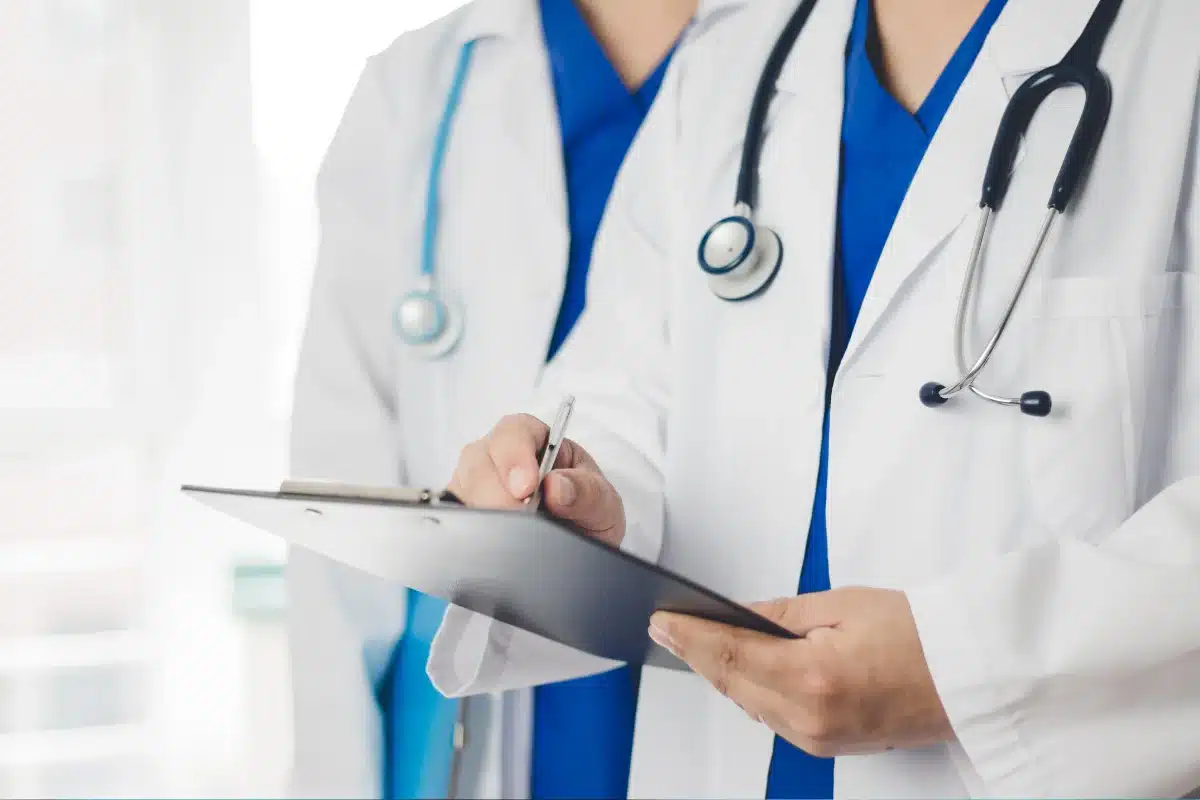 Médico fazendo anotações em um prontuário.