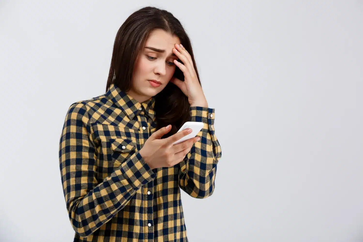 Mulher preocupada olhando o celular, representando o impacto emocional da comparação nas redes sociais.