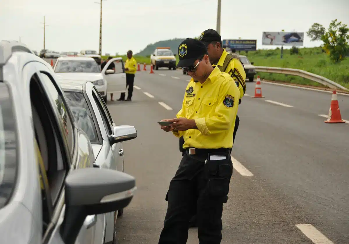 Agente de trânsito do Detran realizando fiscalização em rodovia, ilustrando o processo seletivo.