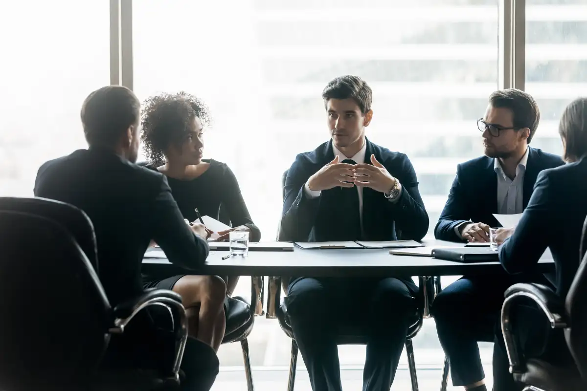 Profissões que mais atraem psicopatas Reunião de equipe em ambiente corporativo com profissionais discutindo ideias em uma mesa.