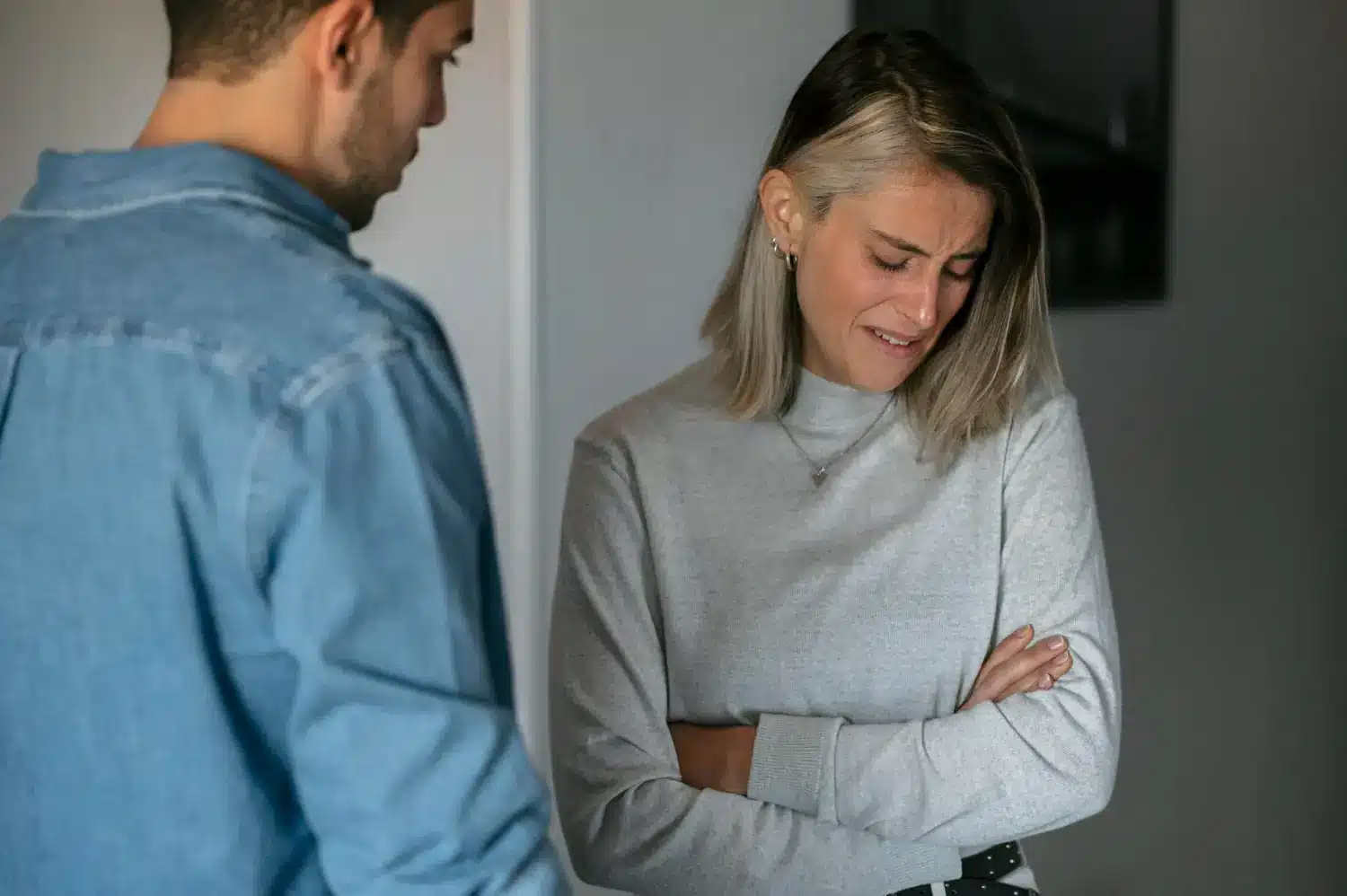 Manipulação emocional disfarçada de mal-entendido Mulher triste sendo confrontada por homem durante discussão tensa.