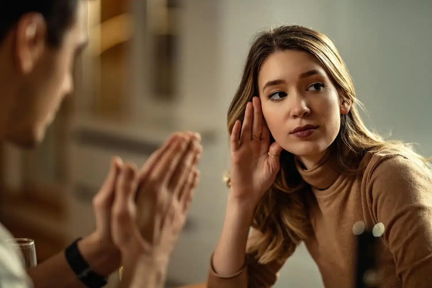 Interação superficial em um relacionamento Mulher ouvindo com desinteresse durante uma conversa, sugerindo falta de conexão emocional
