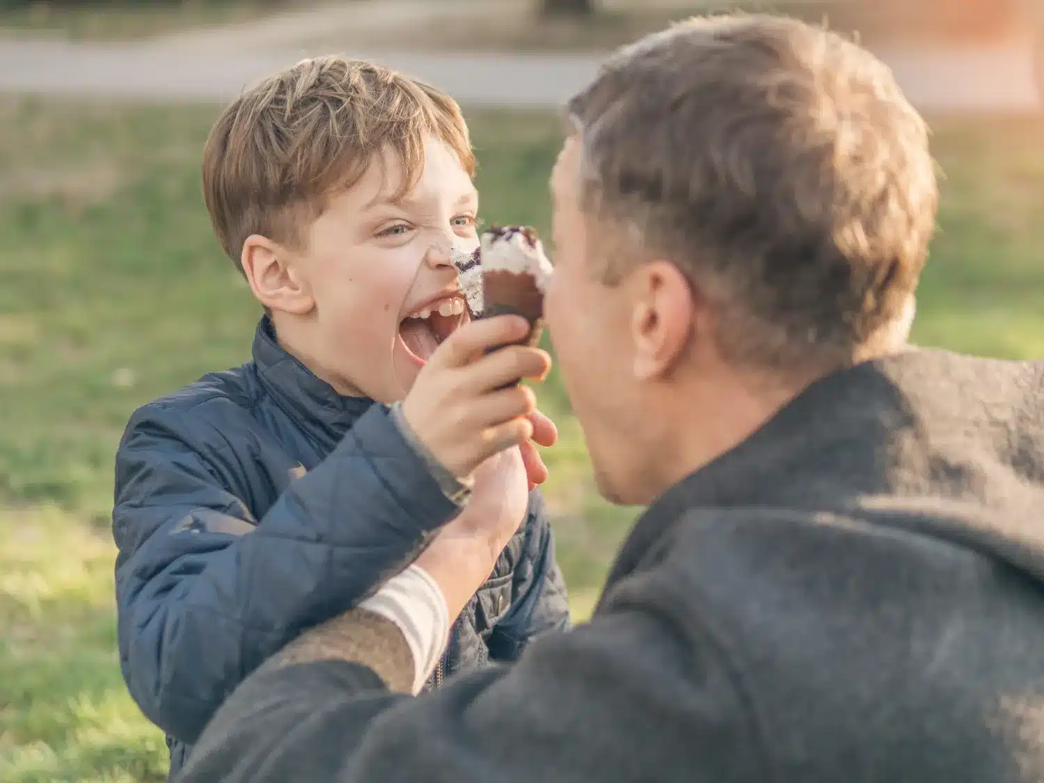 Pai e filho desfrutando de sobremesa juntos. Pai e filho compartilhando uma sobremesa, reforçando a importância de uma relação positiva com a alimentação.
