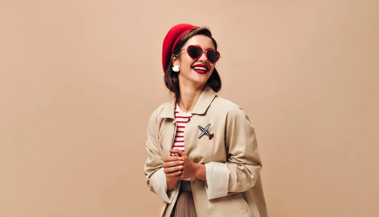 O vestuário como expressão de identidade Mulher sorrindo com roupas que refletem estilo pessoal e identidade, usando óculos de sol e chapéu vermelho