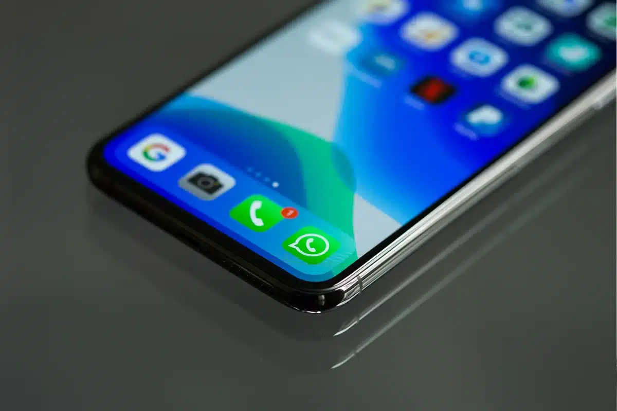 Imagem mostrando um smartphone com ícones de aplicativos de chamadas e WhatsApp na tela.