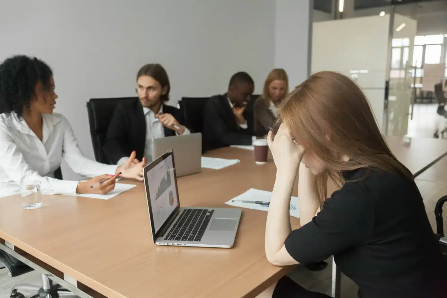 Insegurança ao defender ideias profissionais Mulher com expressão de frustração durante uma reunião de trabalho, demonstrando insegurança ao defender suas ideias.