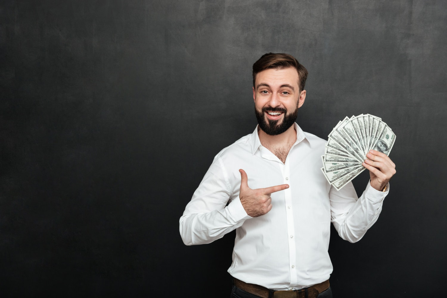 Homem sorridente segurando uma grande quantidade de dinheiro em notas, simbolizando sucesso financeiro e oportunidades de emprego.