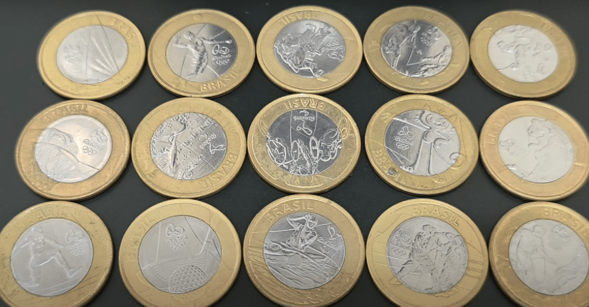 Diversas moedas comemorativas das Olimpíadas brasileiras exibidas em fundo preto.