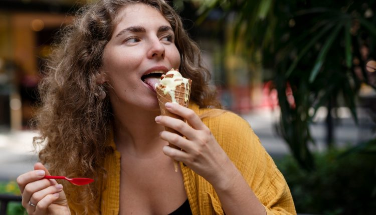 Prazer simples: sorvete de baunilha e personalidade Mulher saboreando sorvete de baunilha em casquinha, demonstrando satisfação e leveza
