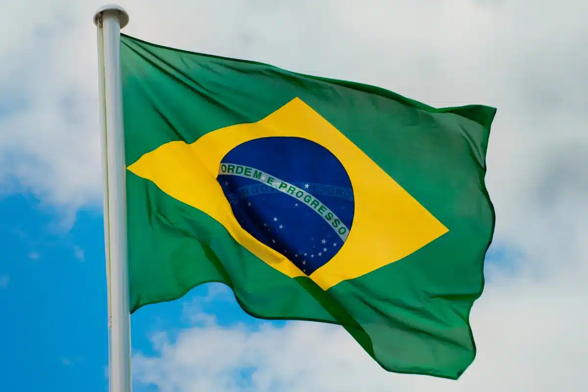 Bandeira do Brasil tremulando no mastro em dia de céu azul