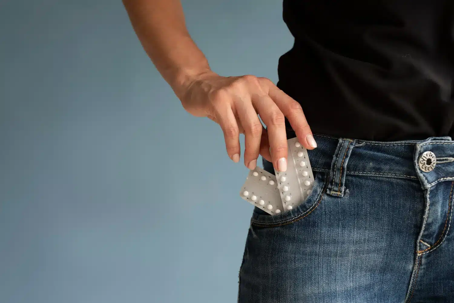 Métodos Contraceptivos Gratuitos Disponíveis no SUS Mulher retirando cartela de anticoncepcional do bolso, representando métodos contraceptivos gratuitos oferecidos pelo SUS.