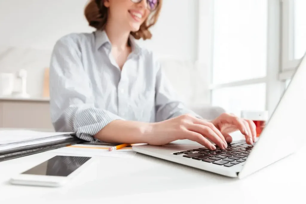 Como fazer uma denúncia ao INSS: orientações práticas Mulher digitando em laptop, preparando denúncia ao INSS