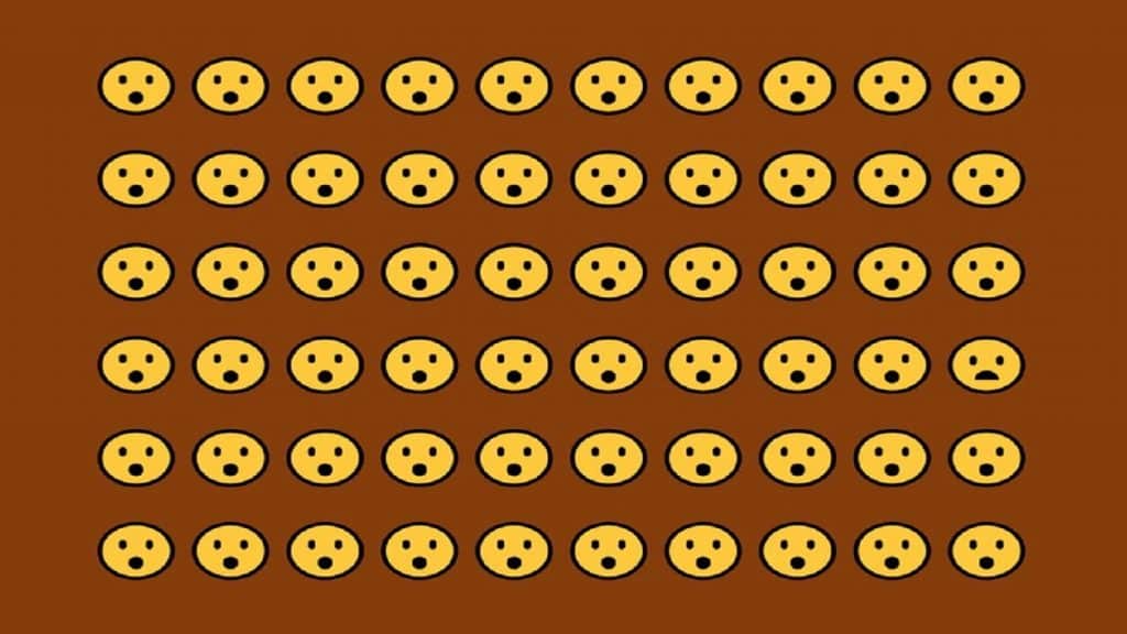 Desafio visual com uma grade de emojis com expressões surpresas, destacando um rosto triste no canto inferior direito.