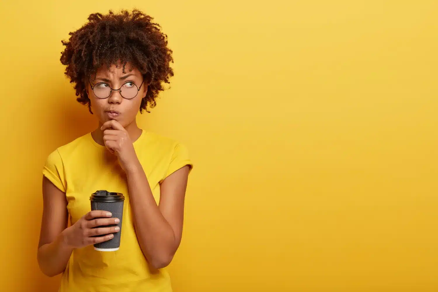 Mulher pensativa com copo de café, questionando o feminino de embaixador