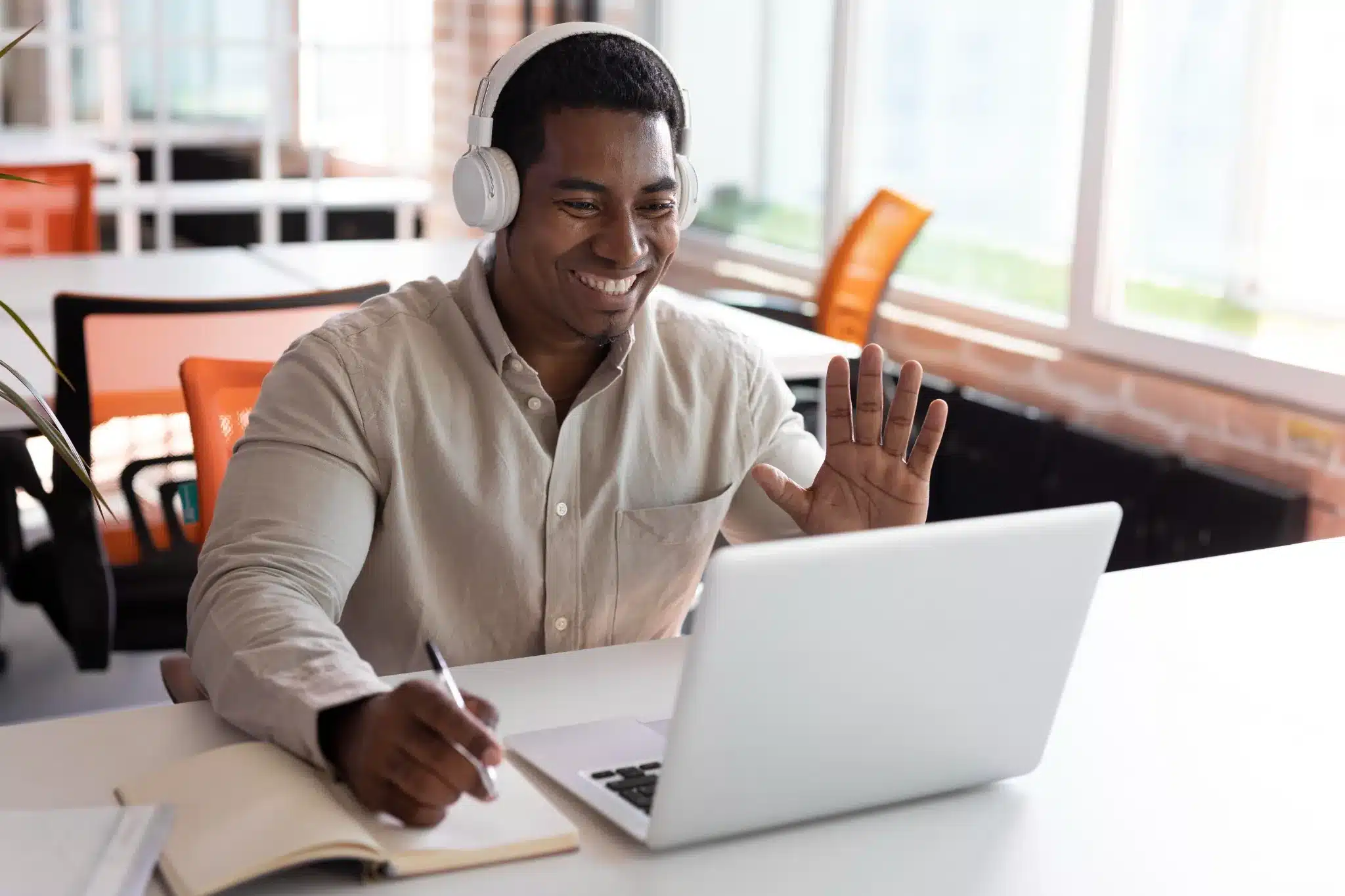 Homem sorrindo durante aula online com fones de ouvido
