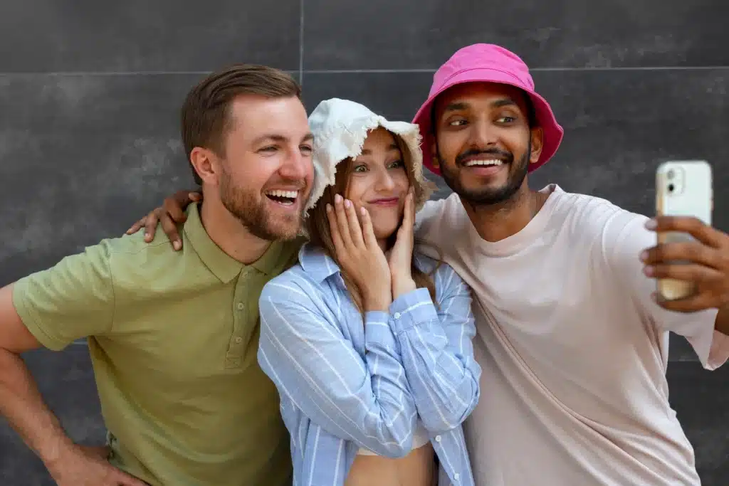 Amizade e expressões sociais espontâneas em selfie Três amigos animados tirando selfie, mostrando diferentes expressões e alegria em um momento social