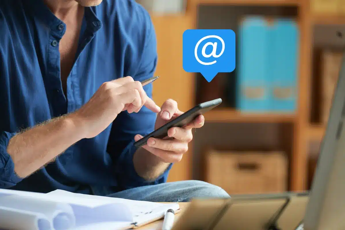 Homem usando smartphone para enviar e-mails ou mensagens eletrônicas.