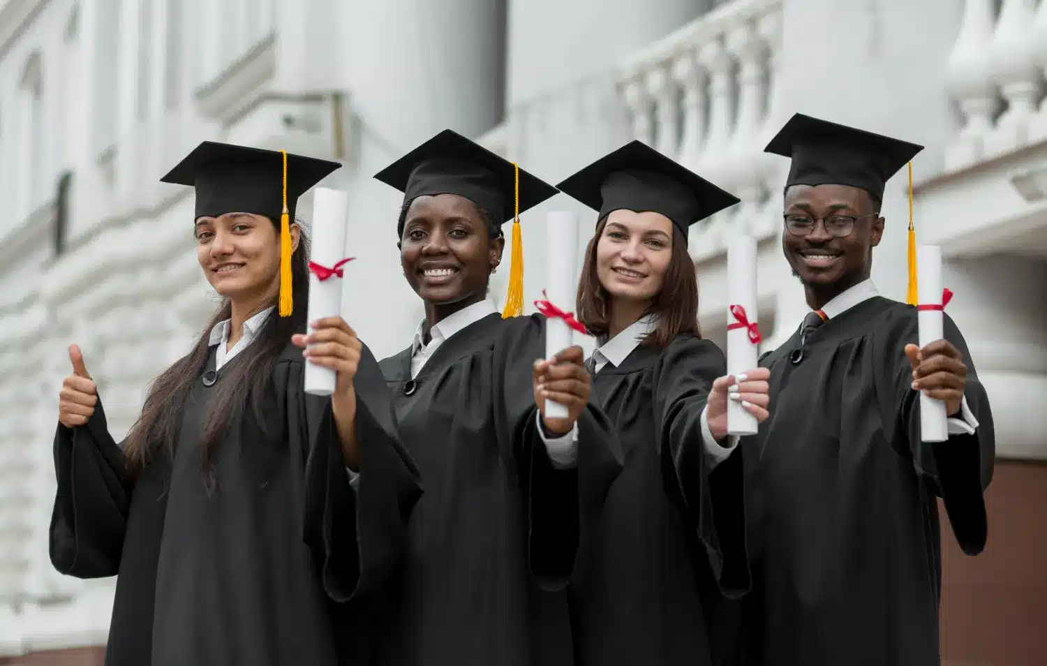 Estudantes comemorando a formatura na universidade Grupo diversificado de estudantes universitários sorrindo e segurando diplomas após a formatura.Título: Estudantes comemorando a formatura na universidade.