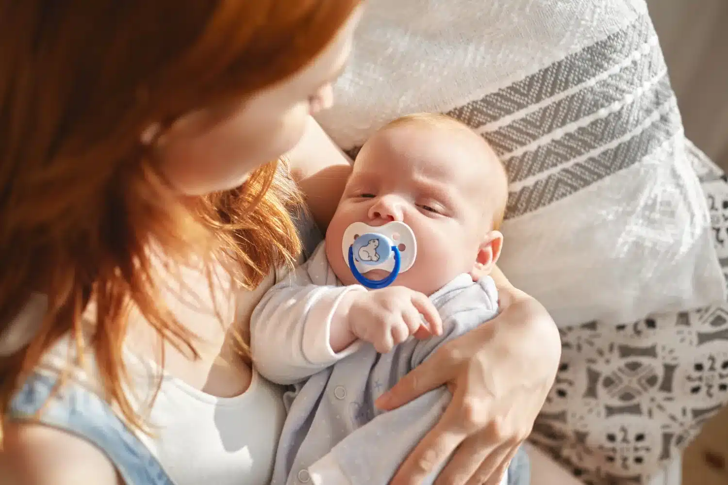 Mãe segurando carinhosamente seu bebê reborn com chupeta azul