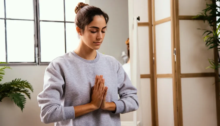 Meditação: um dos hábitos que deixam você mais inteligente, segundo Harvard Mulher em posição de meditação, praticando mindfulness em ambiente tranquilo