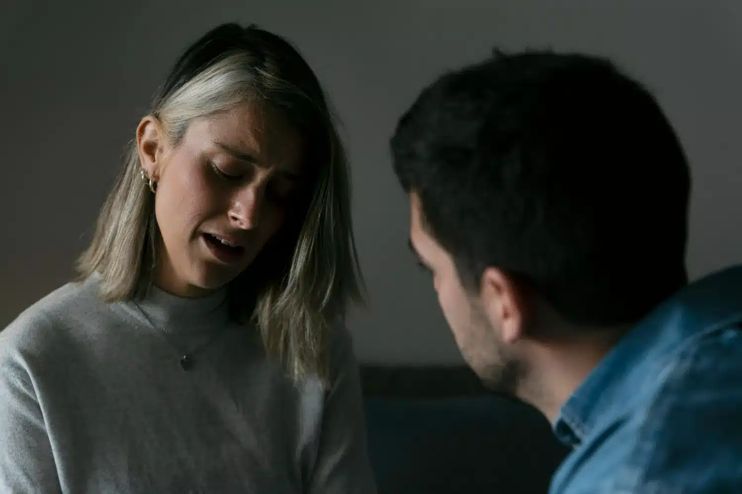 Culpa projetada em relacionamento narcisista Mulher angustiada diante de homem, representando culpa imposta por manipulação emocional.