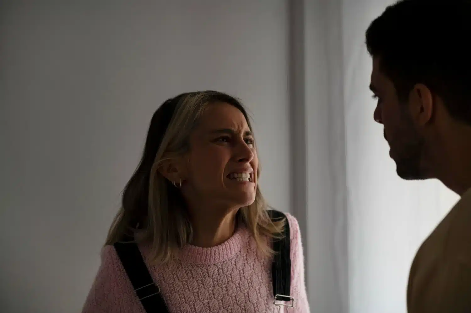 Mulher expressando frustração e raiva em conversa, ilustrando os impactos emocionais de interações com um narcisista.