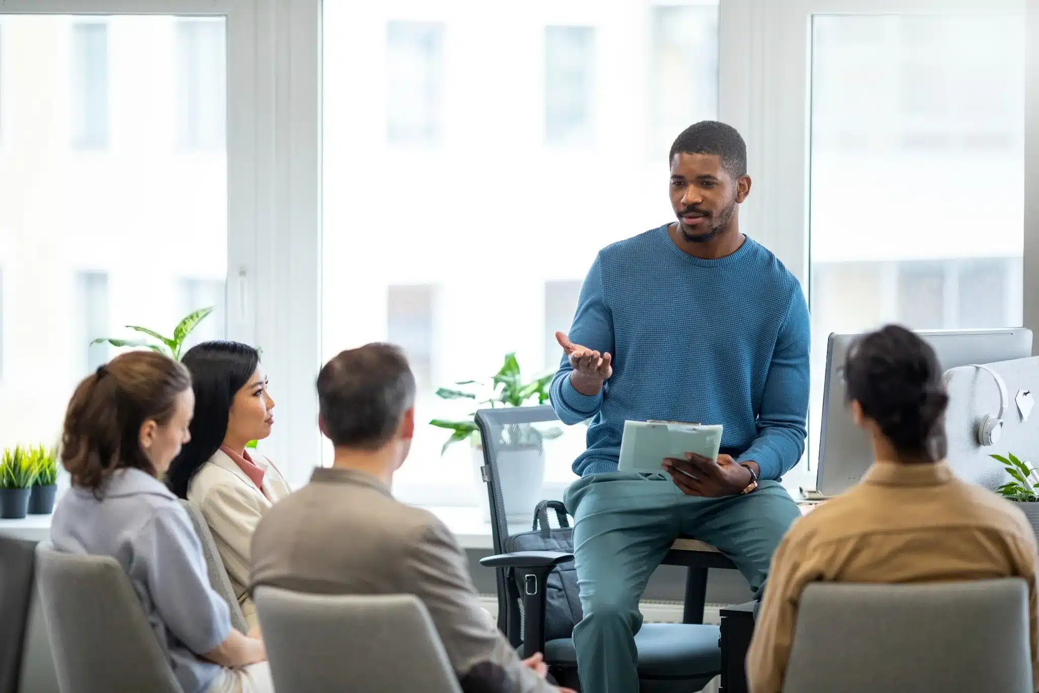 Treinamento corporativo em ambiente colaborativo Profissional conduzindo treinamento com equipe no escritório