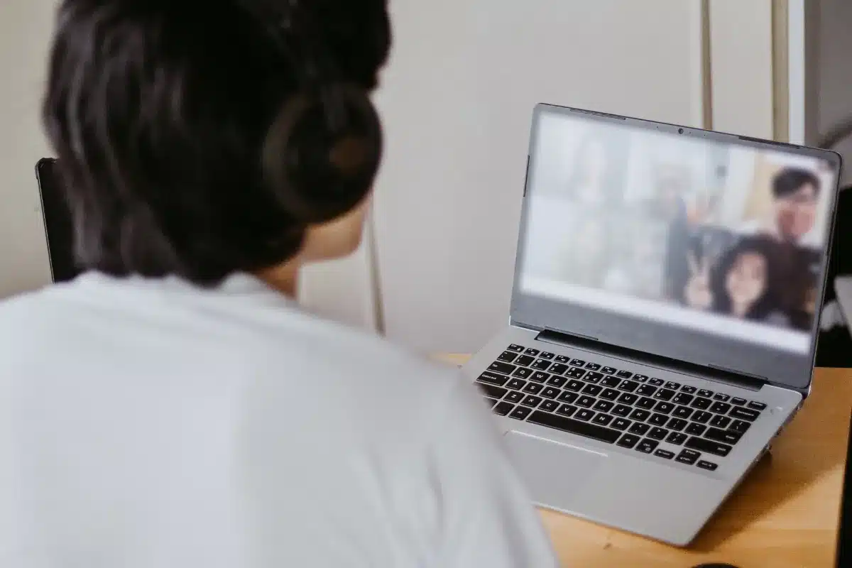 Estudos online Pessoa participa de videoconferência com grupo de amigos ou colegas usando notebook.