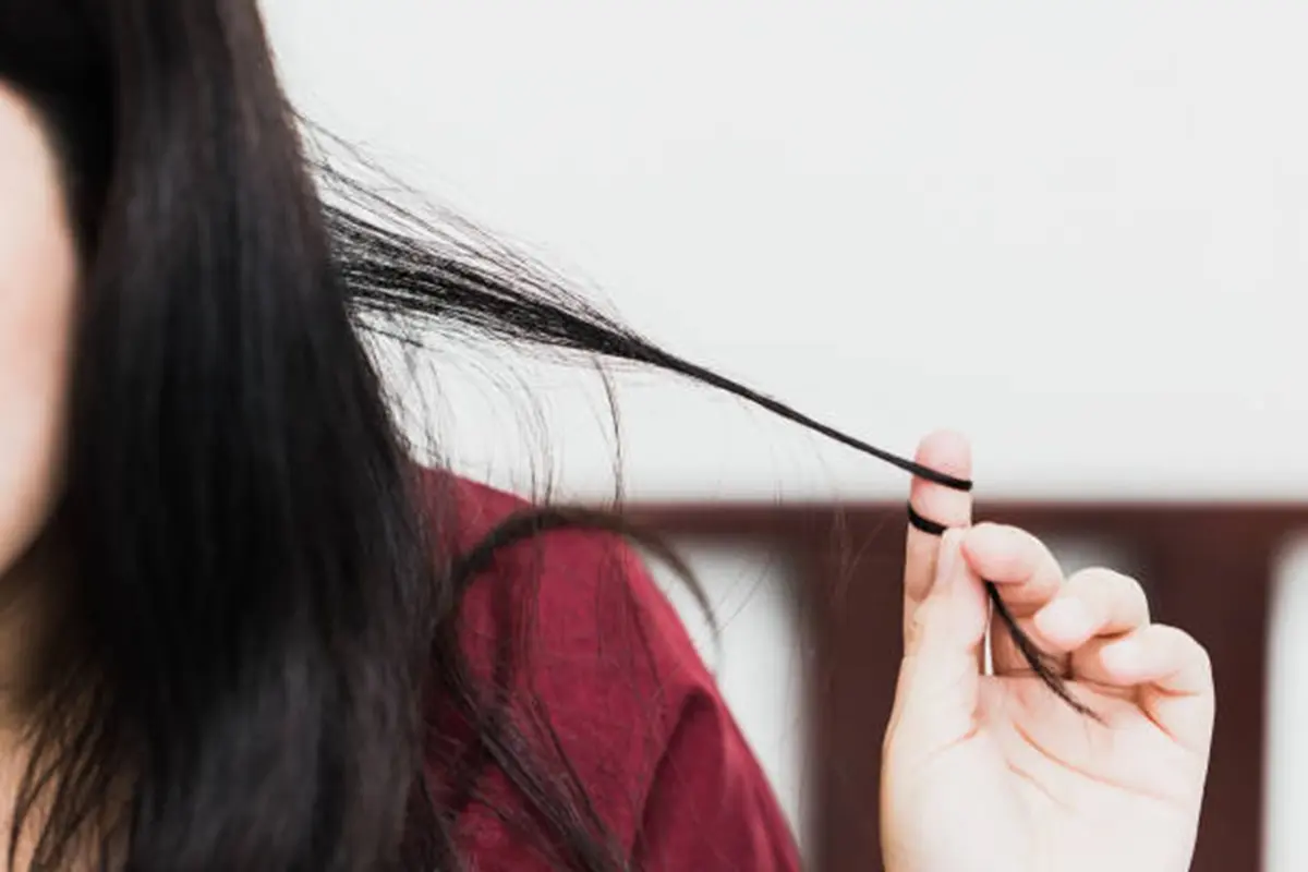 Pessoa puxando mecha de cabelo, um comportamento associado ao transtorno de tricotilomania
