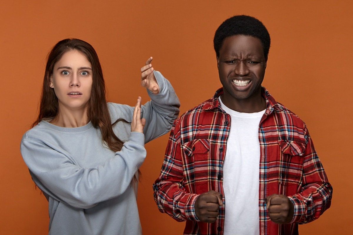 Casal discutindo em um ambiente fechado, simbolizando os sinais de estresse e ansiedade quando há dificuldades em resolver conflitos.