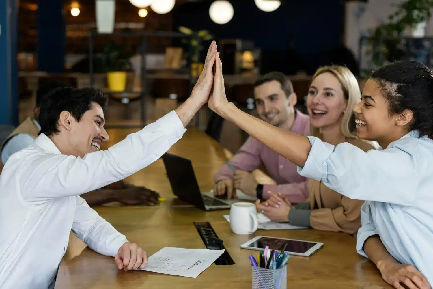 Colaboradores realizando uma comemoração no ambiente de trabalho, com um toque de alta interação e alegria.