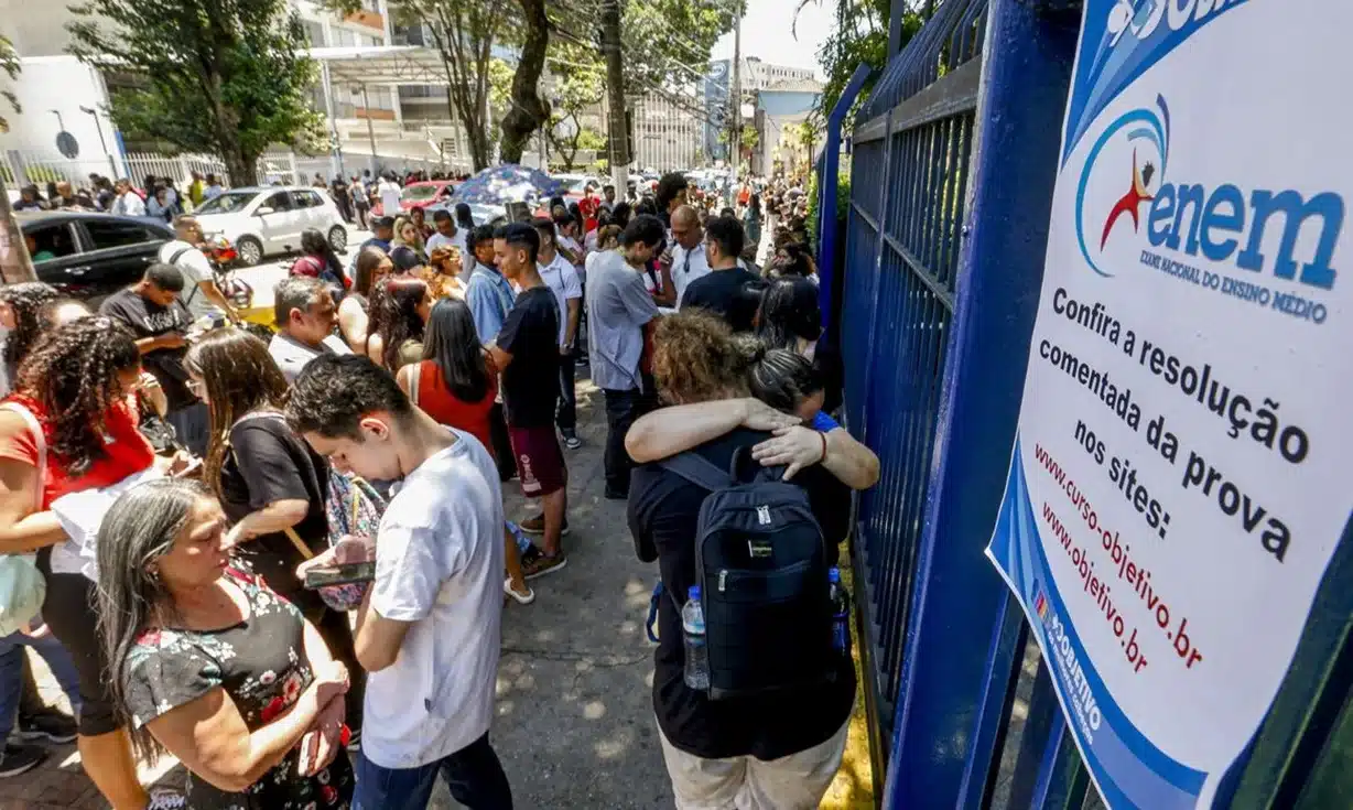 Estudantes aguardando para realizar o Exame Nacional do Ensino Médio (Enem) em frente ao local de prova.