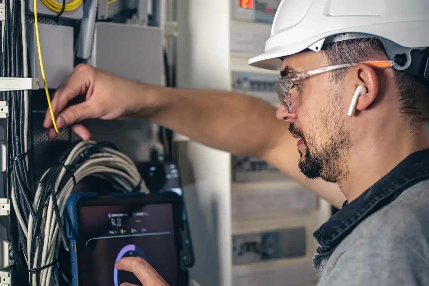 Manutenção em sistemas elétricos - Técnico em Eletrotécnica. Técnico em eletrotécnica realizando manutenção em sistema elétrico.
