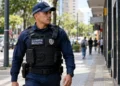 Guarda municipal uniformizado durante patrulhamento em uma rua.
