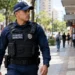 Guarda municipal uniformizado durante patrulhamento em uma rua.