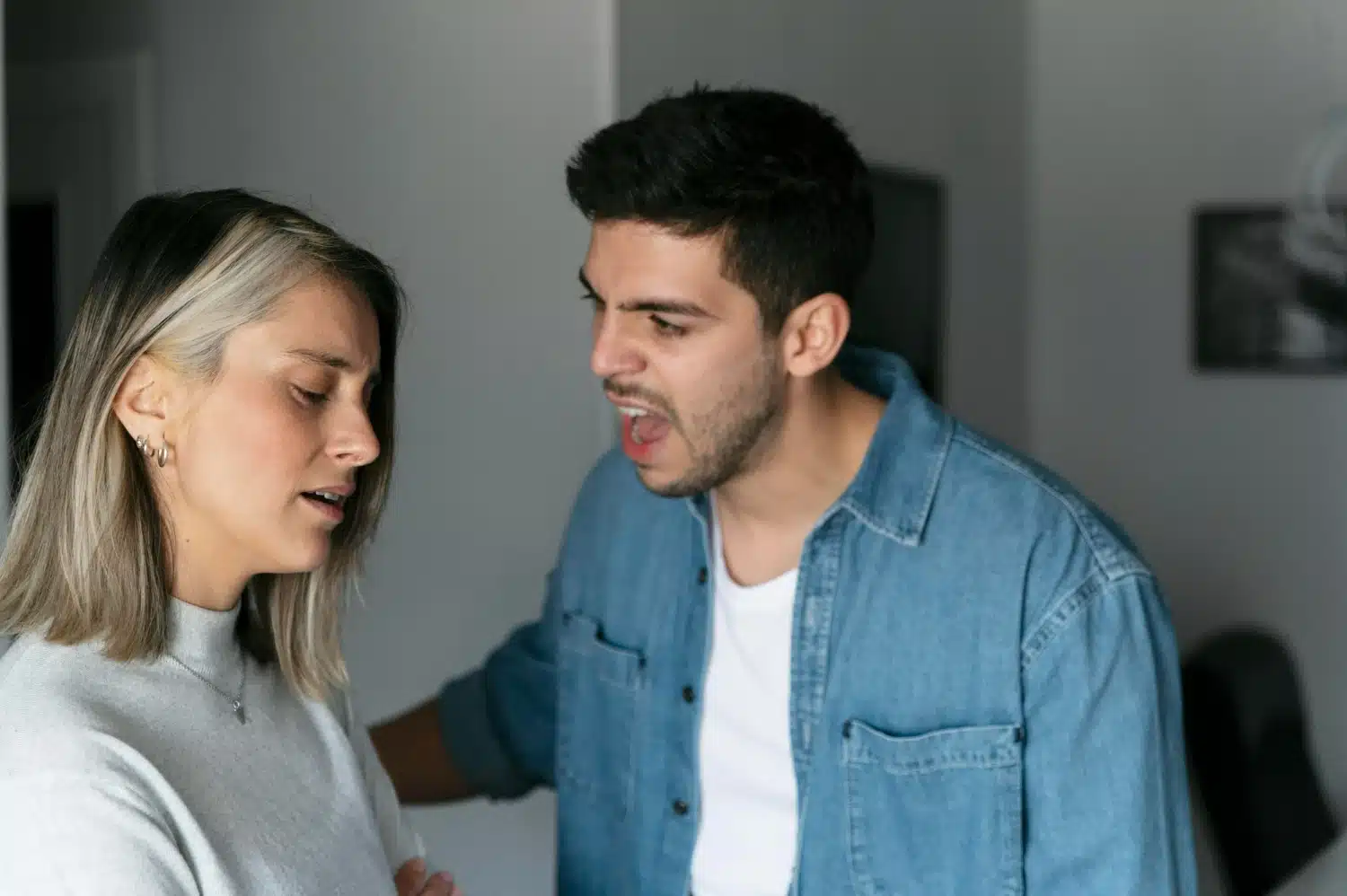Discussão tensa entre homem e mulher. Homem falando com expressão de raiva para uma mulher que parece triste e desconfortável.