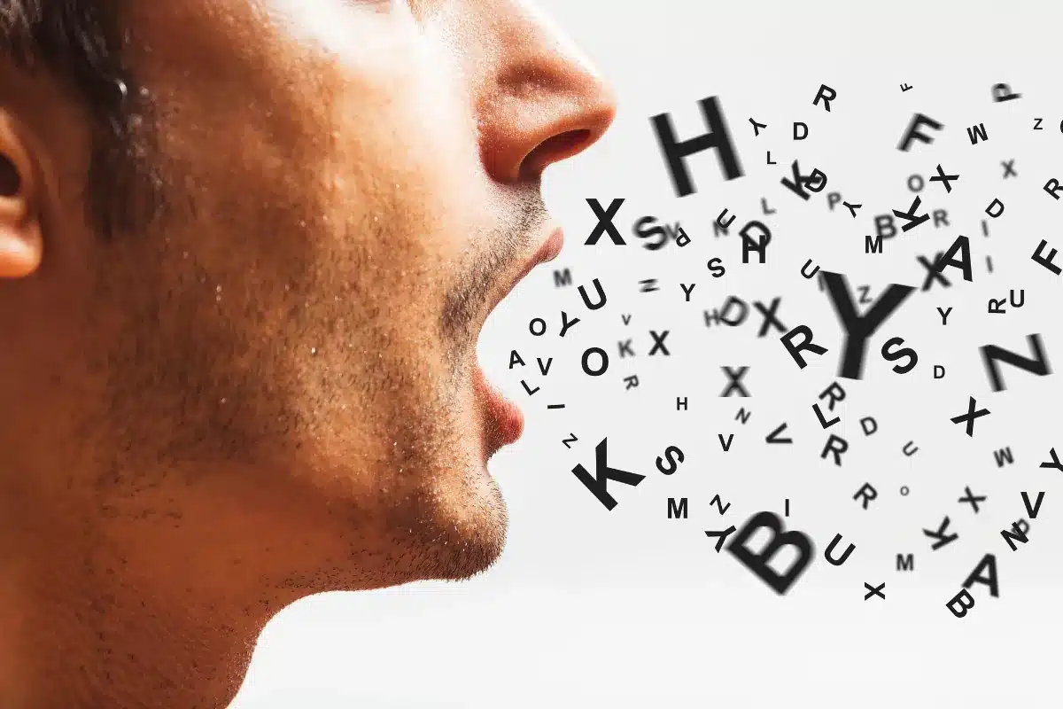 Homem falando com letras flutuando no ar, representando sons e pronúncia.