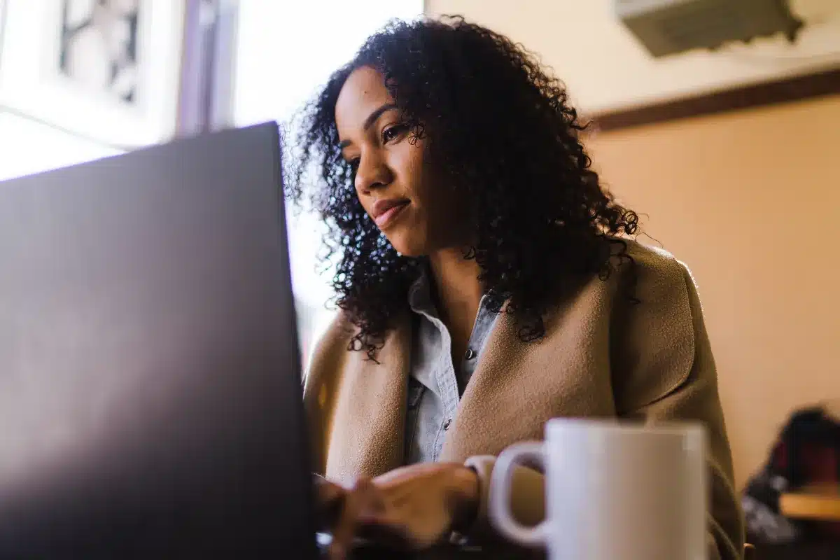 Mulher usando notebook com atenção em ambiente interno
