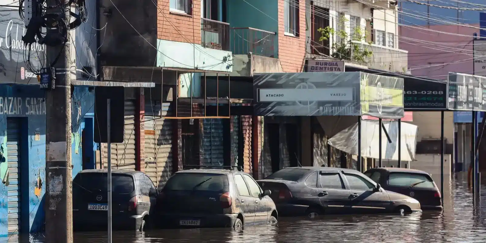Saque calamidade FGTS Rua com carros submersos após enchente em área urbana.