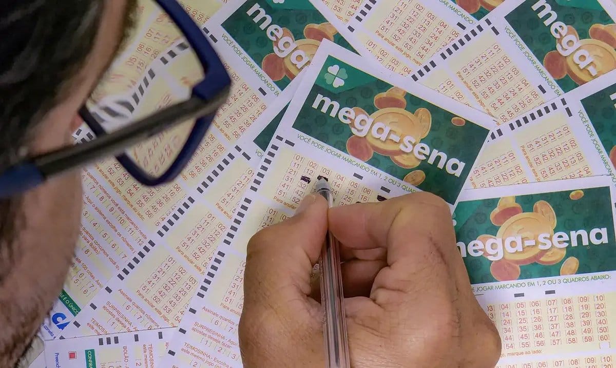 Pessoa marcando números em volante da Mega-Sena acumulada.