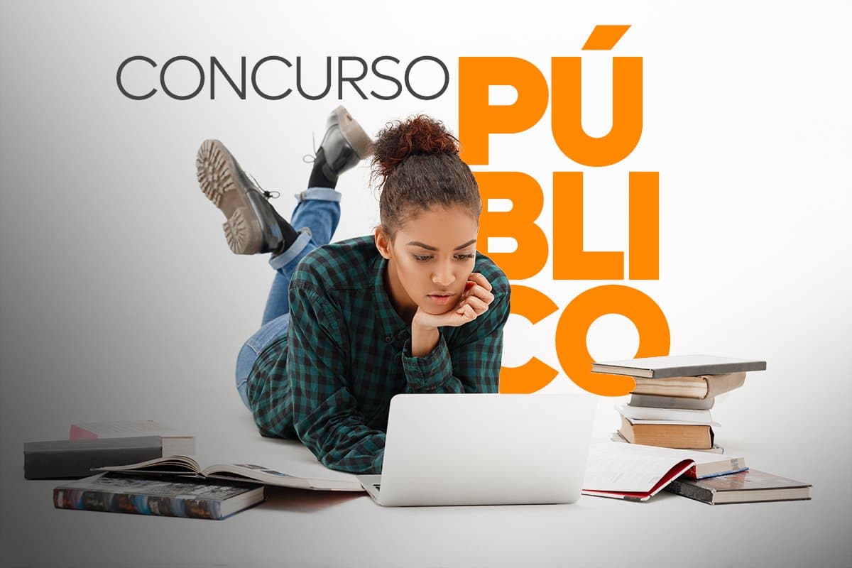 Jovem estudando online para concurso público rodeada de livros.