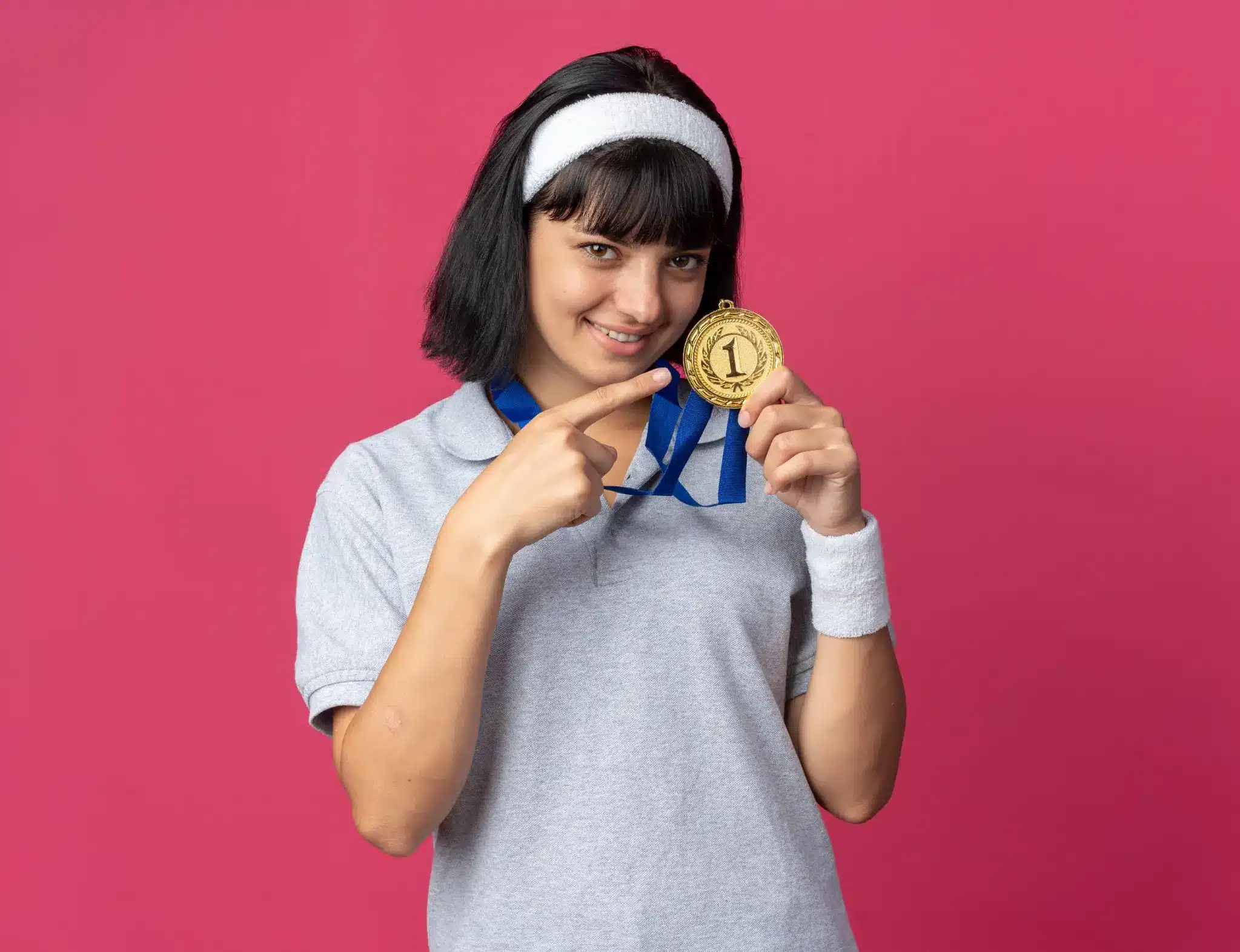 Garanta R$ 400: últimos dias para participar da competição nacional de educação financeira Jovem com medalha de ouro sorrindo e apontando para a medalha, simbolizando a competição nacional de educação financeira para ganhar R$ 400.