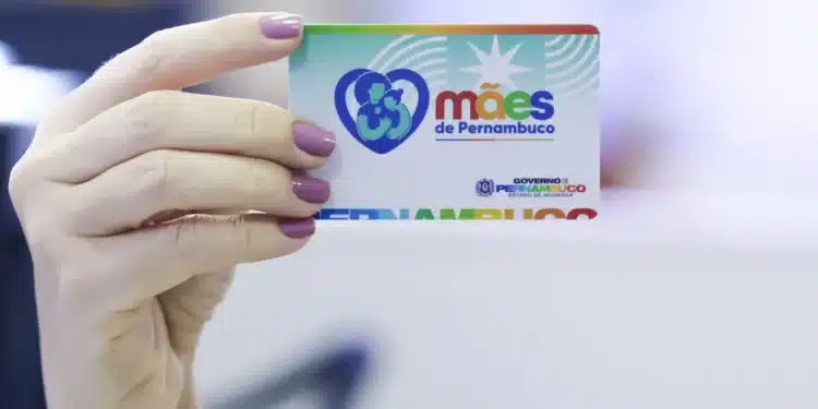 Programa Mães de Pernambuco: Guia de Inscrição e Benefícios. Mão segurando o cartão do programa "Mães de Pernambuco".
