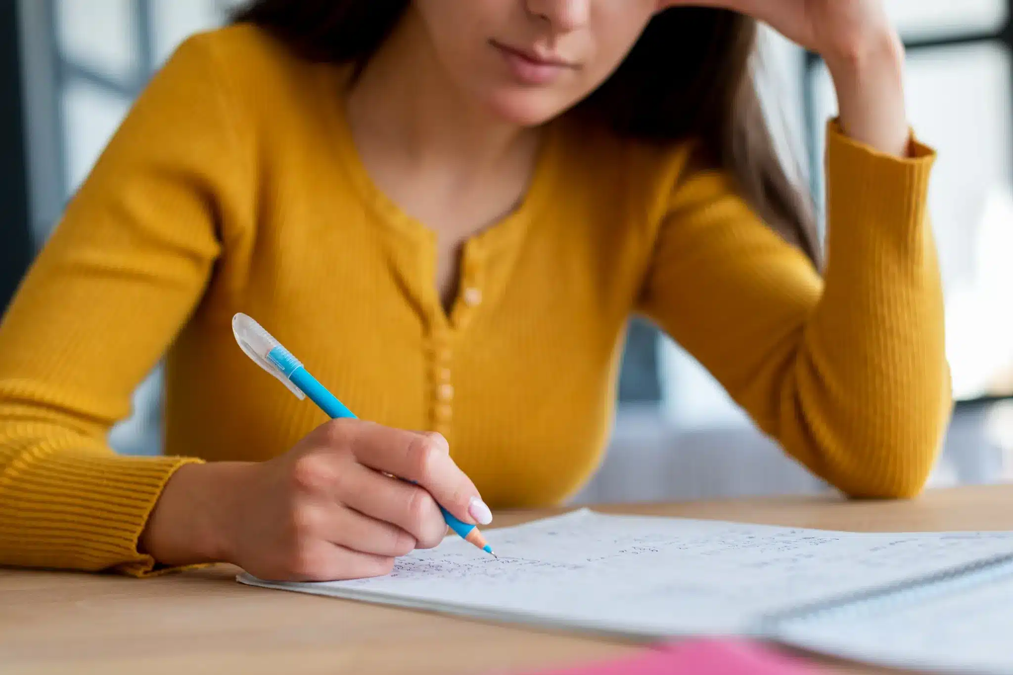 Concurso Câmara Municipal Mulher estudando e fazendo anotações em caderno.