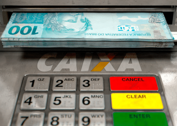 Caixa eletrônico da Caixa Econômica Federal com notas de cem reais disponíveis para saque